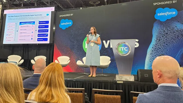 A presenter on the Growth Stage beside a slide titled Your New Producer OS, Powered By Digital Teammates.